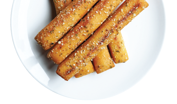 Seasoned breadsticks on a white plate